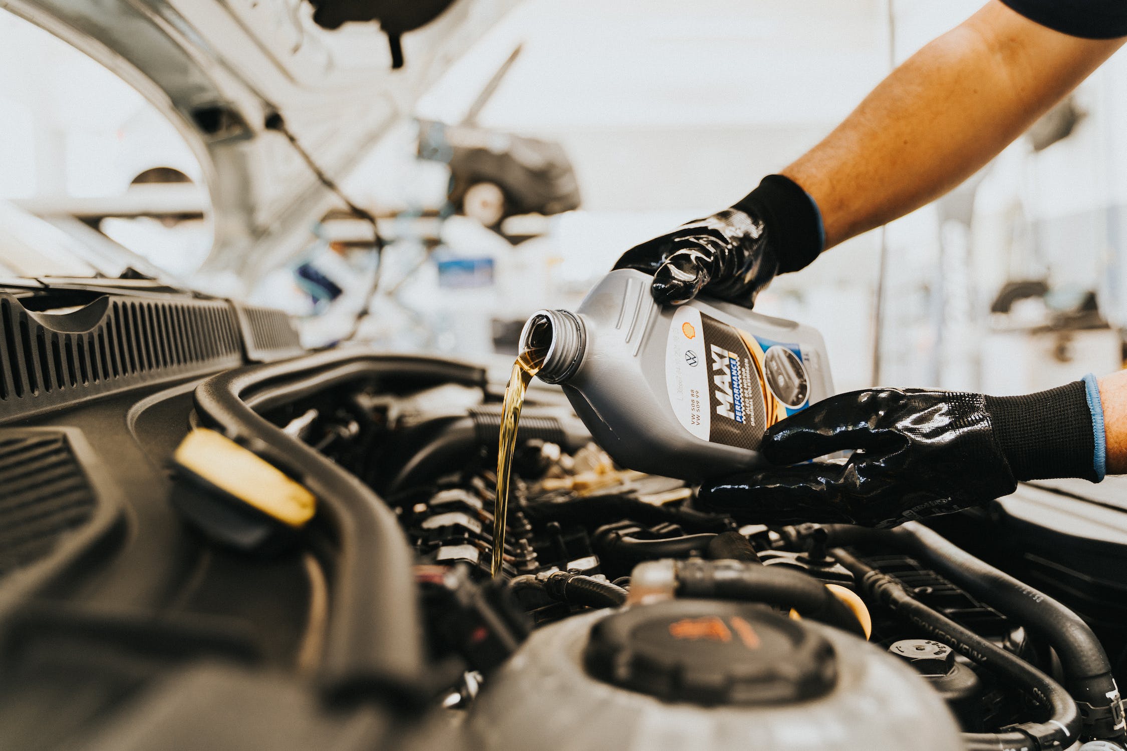 Oil change service being performed on vehicle engine at auto repair shop
