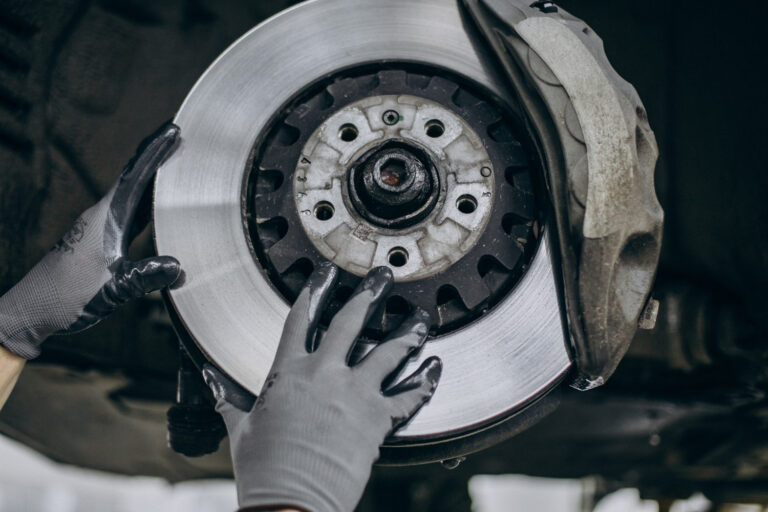 Mechanic inspecting brake pads and rotors at J&C Auto Services Douglasville GA