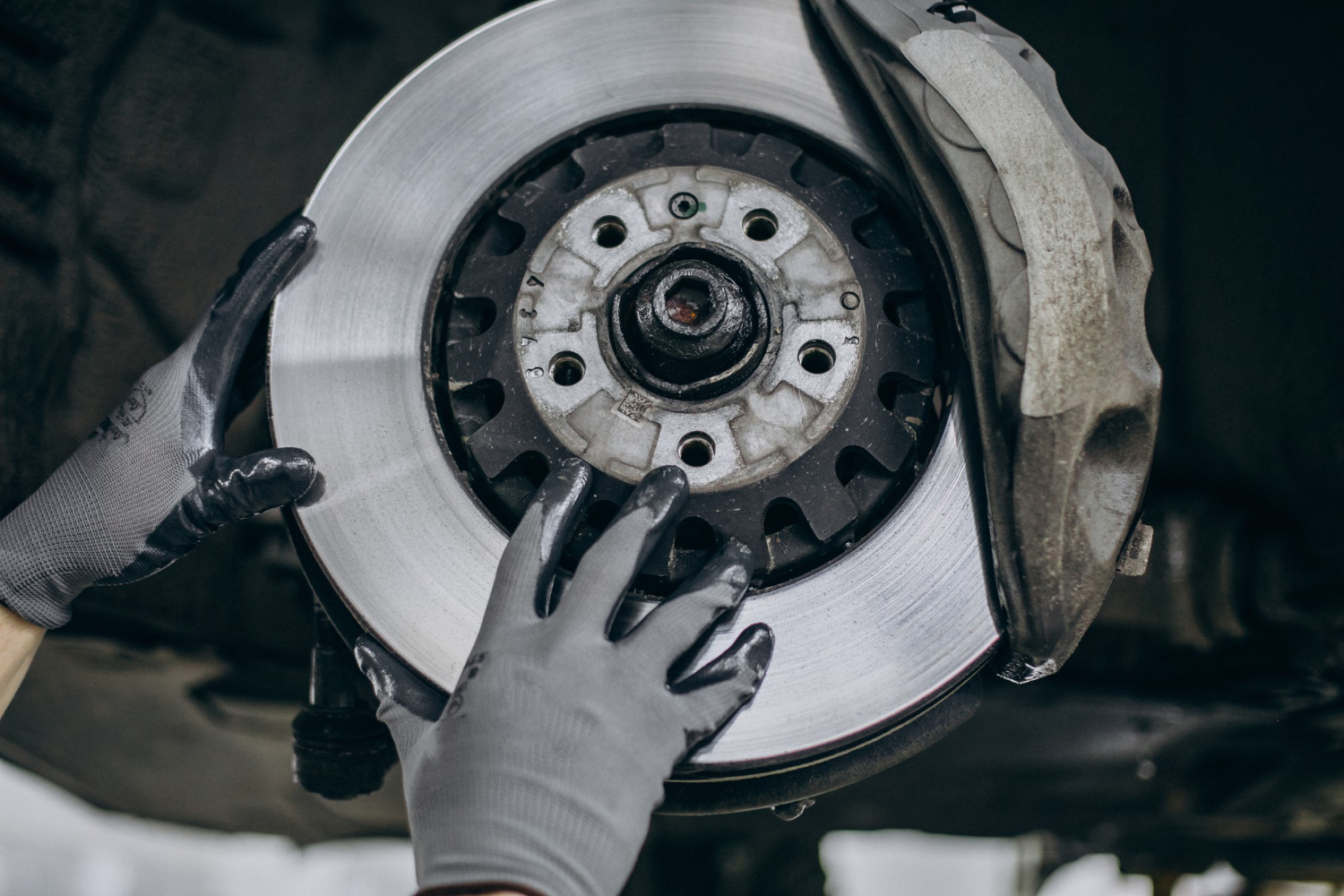 Mechanic inspecting brake pads and rotors at J&C Auto Services Douglasville GA